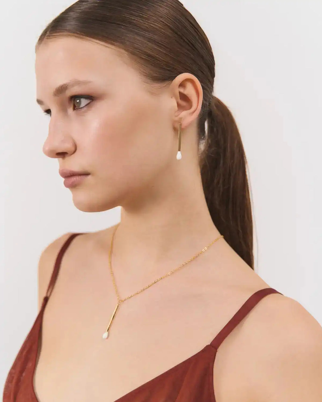 Сережка 6.674 у формі довгого срібного сірника в позолоті з білою емаллю